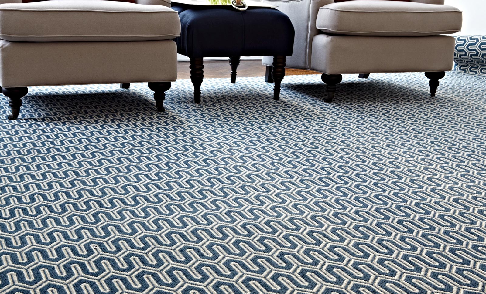A patterned carpet shown across a full floor, where the pattern reads differently than it does on a small sample