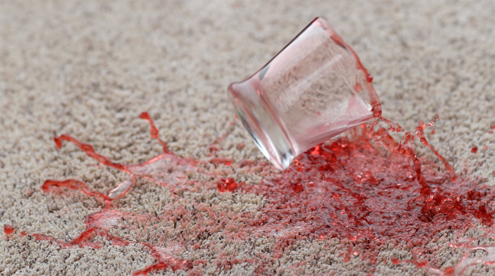 Red juice spill on carpet showing why stain resistance matters in flooring selection