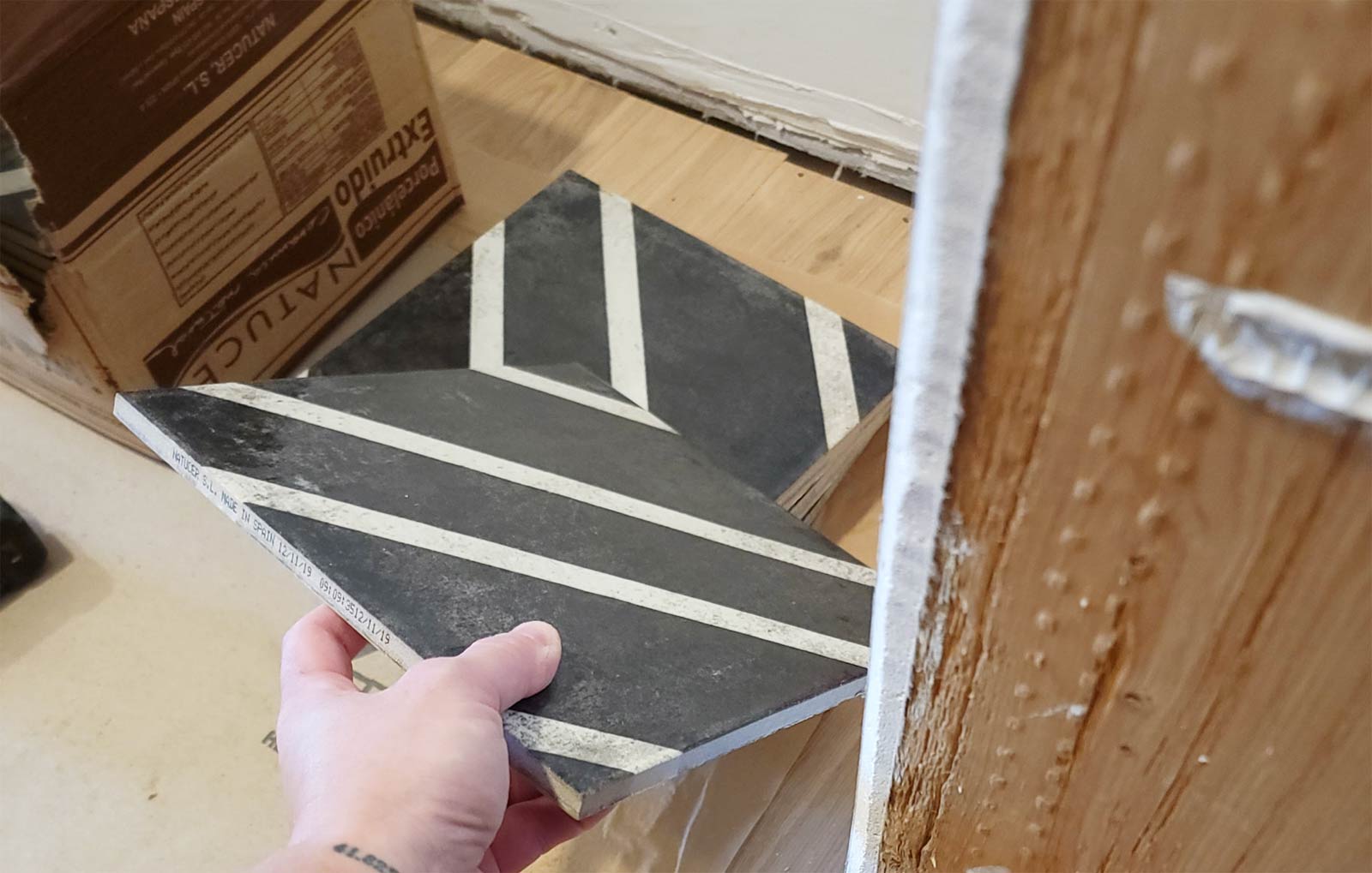 pile of black and white tile with cardboard box in background