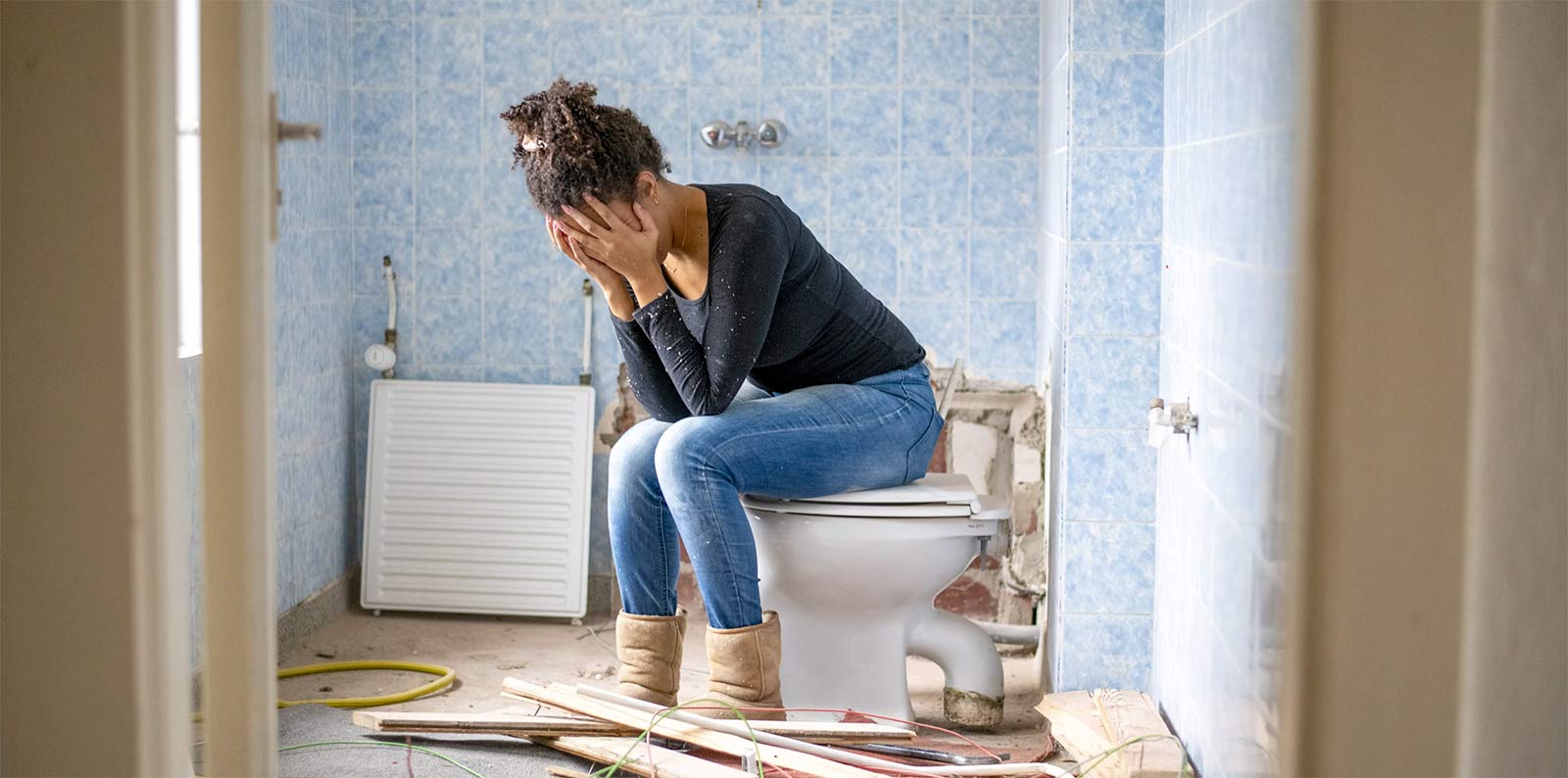 woman sad sitting on toilet bathroom construction