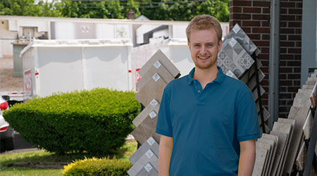 Ian Opaluch standing outside Island Carpet store wearing blue polo shirt