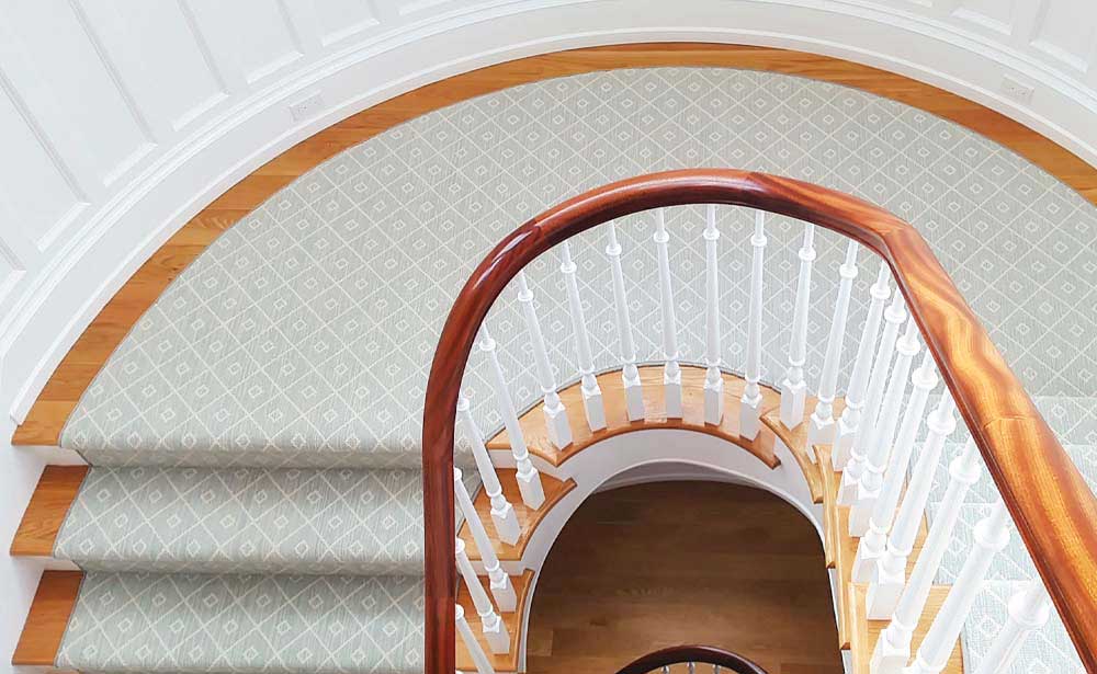 Turquoise carpet installed on wood stair with white walls